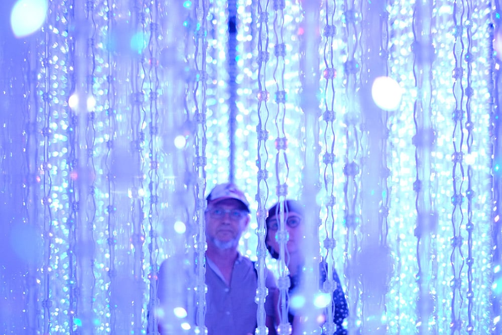 image of a man and a woman standing behind a screen of hanging droplets