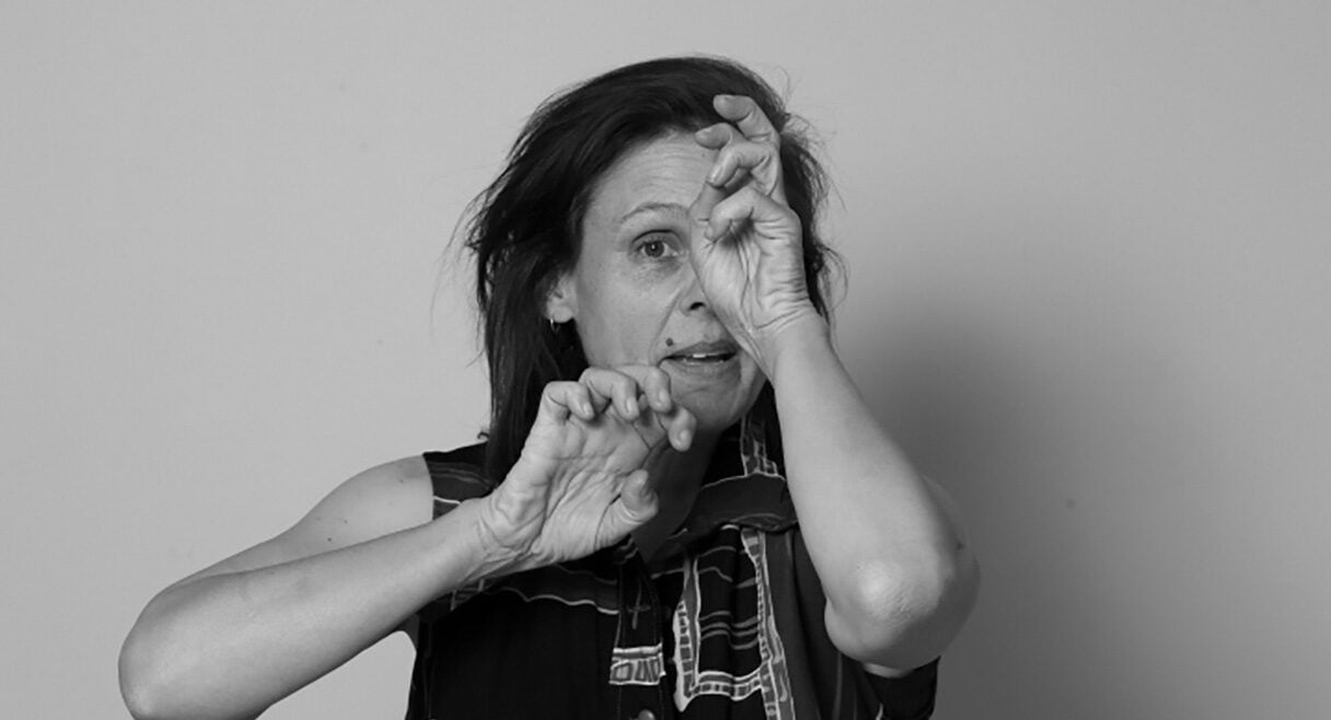 Portrait of Vicki Van Hout in black and white with one hand over her eye, and the other like a claw