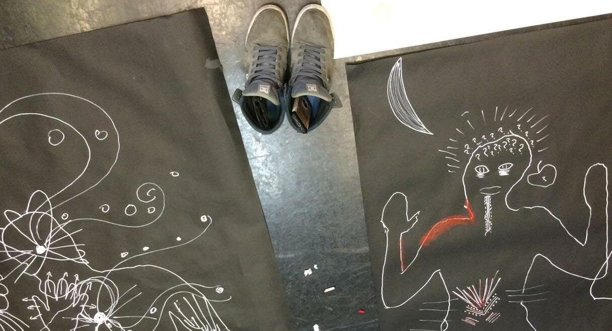 image of drawings on the ground with a pair of ladies shoes