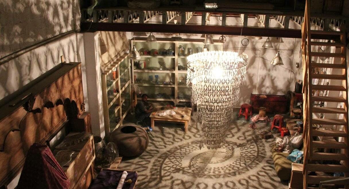 image of a room with chandelier and geometric shadows from lamp shade on the wall