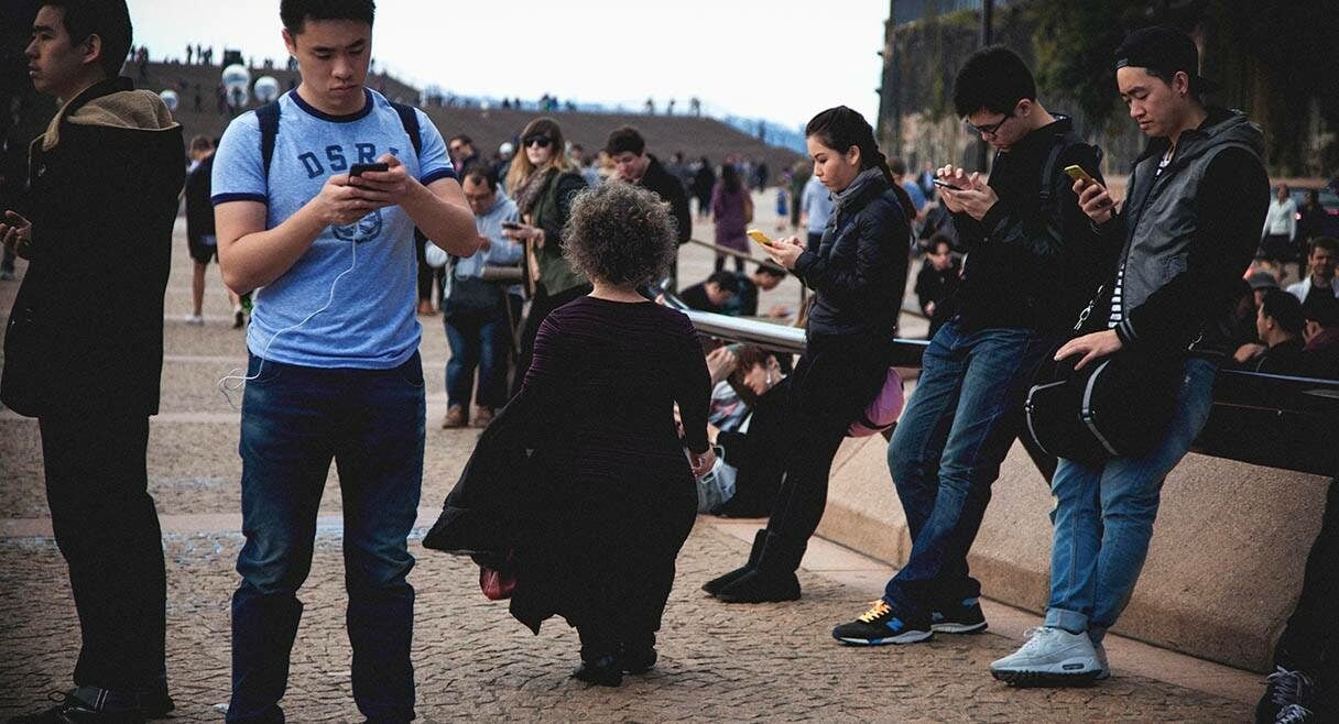 image of artist debra keenahan walking through a crowd of people looking at their phones