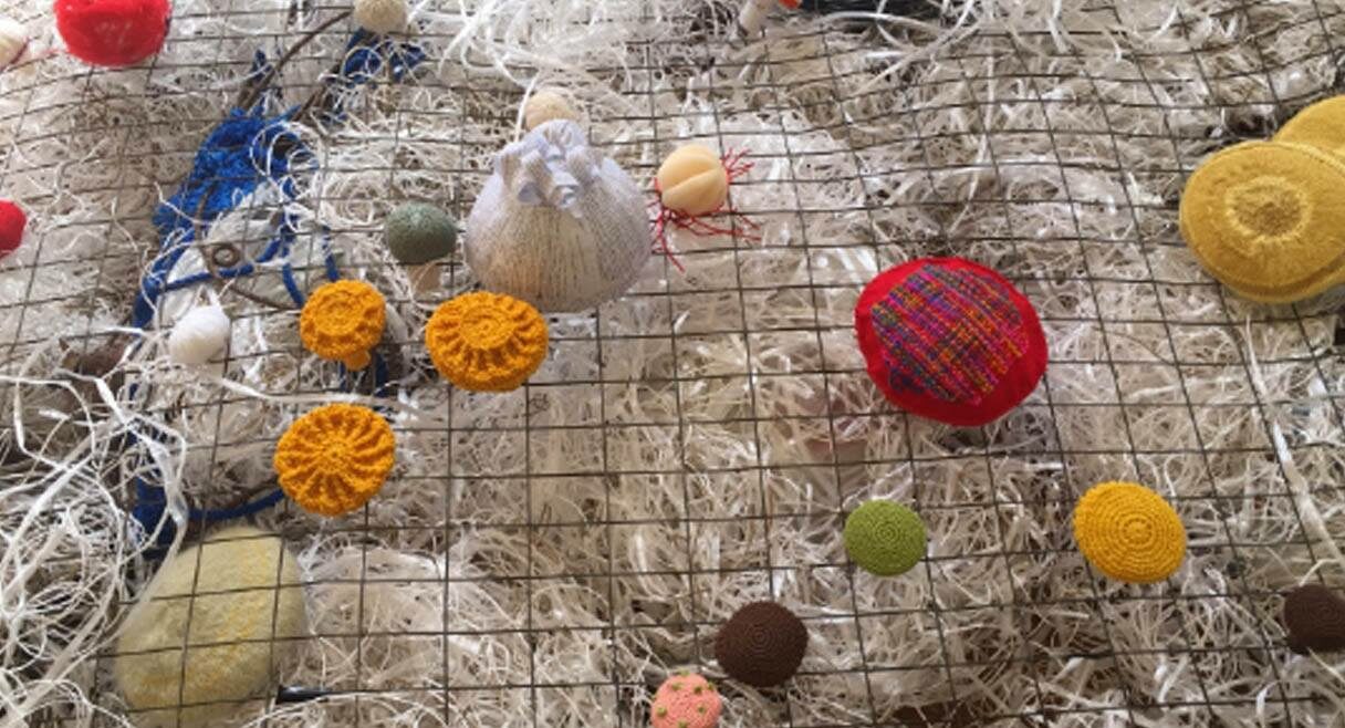 image of handmade wool balls on a net with more wool underneath