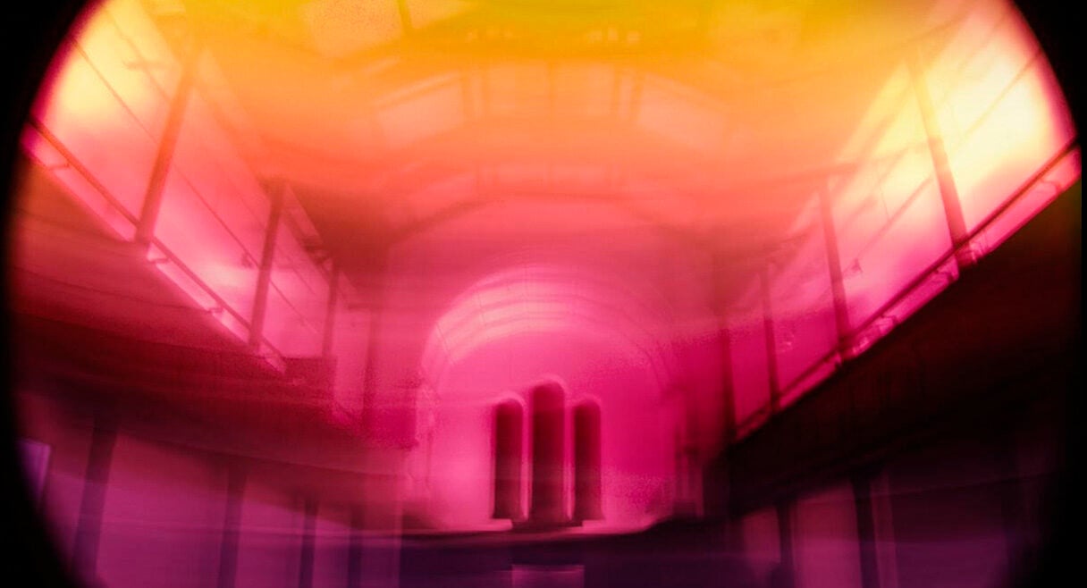 image of an industrial tunnel with pink and yellow hues