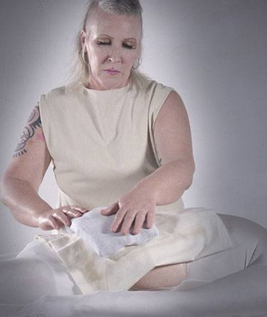 woman administers care to a man on a bed in white lycra